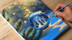 someone is painting a christmas ornament on a canvas