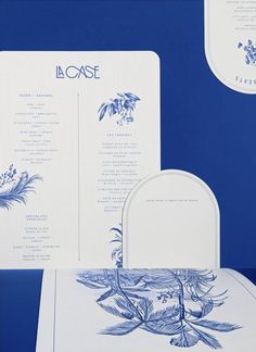 a blue and white wedding stationery with floral designs on it's back side