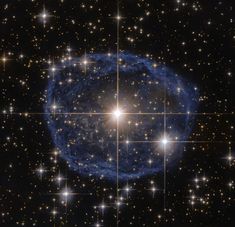 an image of a star cluster in the sky with stars all around it and one large blue object surrounded by smaller white ones