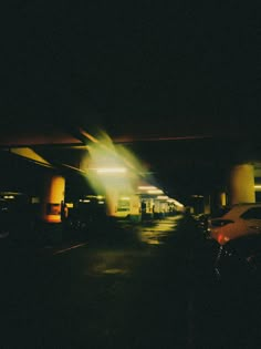 an empty parking garage at night with the lights on and cars parked in the lot