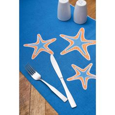 a place mat with starfishs on it next to two salt and pepper shakers