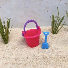 a toy bucket and shovel sitting in the sand