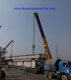 a large crane is in the middle of a construction site with people standing around it