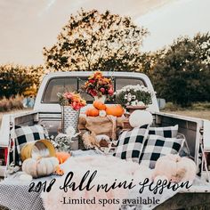 an old truck with pumpkins and fall decorations in the back