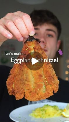 a man holding up a fried eggplant in front of a plate with broccoli on it