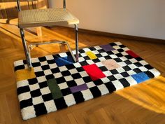 a chair sitting on top of a wooden floor next to a checkerboard rug