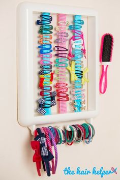 there is a rack with many different hair ties on it and a toothbrush next to it