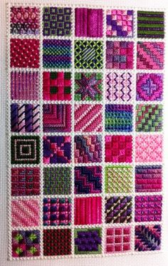 a cross stitch pattern with many different colors and patterns on the fabric, as well as squares