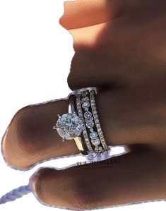 a woman's hand with two diamond rings on her left and the other hand holding an engagement ring