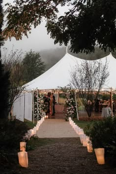 a wedding tent with candles lit up in front of it