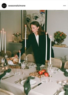 a woman sitting at a table with candles in front of her