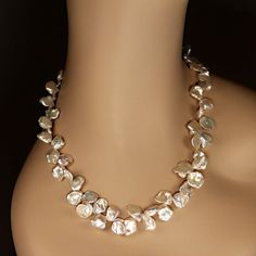 This is part of Chairish’s Fine Jewelry assortment.  Elegant 23-Inch Iridescent Keshi Pearl Necklace  This 23-inch necklace features exquisite white iridescent Keshi pearls, gently graduated in size from 9mm to 14mm. These uniquely shaped pearls, with their flat and rounded silhouettes, exude a luminous glow and captivating iridescence that effortlessly makes a statement.  Designed for both beauty and comfort, the necklace is secured with a versatile silver-plated toggle clasp featuring expandab