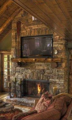 a living room with a fire place and television mounted on the wall above it's fireplace