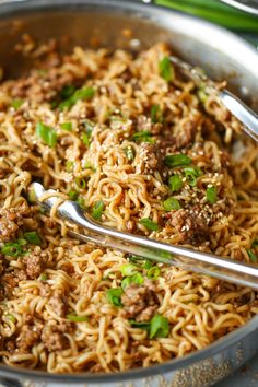 a pan filled with noodles and meat on top of a table