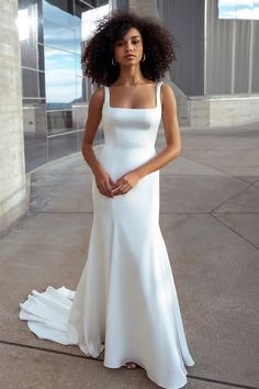 a woman in a white dress posing for the camera