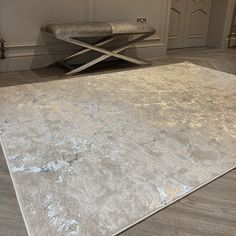 an area rug in the middle of a room with a bench and chair behind it