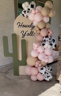 balloons are arranged in the shape of a cactus and cow heads, along with a sign that says hollywood y'all