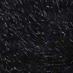 black and white photograph of snow flakes in the night sky with stars moving through it