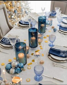 the table is set with blue glassware and gold confetti, as well as candles