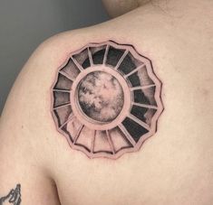 a man with a tattoo on his shoulder that has the sun and moon in it