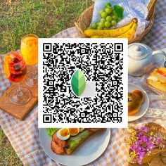 a picnic table with food and drinks on it, including bread, grapes, fruit, and tea