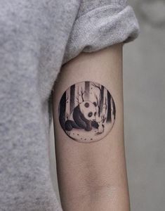 a panda bear tattoo on the arm