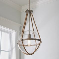 a light hanging from the ceiling with rope wrapped around it and a glass bowl on top