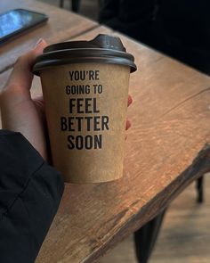 a person holding a coffee cup that says you're going to feel better soon