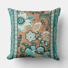 an orange and green pillow with blue trimmings on the sides, featuring flowers