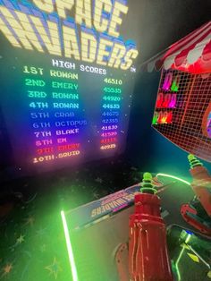 an arcade machine with neon lights and games on the screen in front of it's display