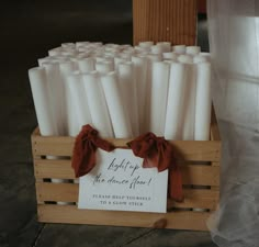 a wooden crate filled with lots of white candles