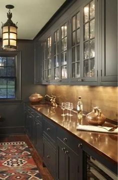 a kitchen with dark cabinets and wooden counter tops