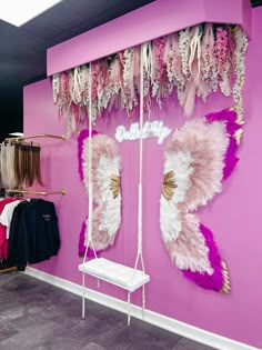 a pink wall with angel wings hanging from it's sides