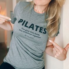 a woman wearing a t - shirt that says pilates the blue that holds this ashtray together