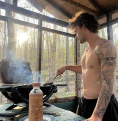 a shirtless man cooking on an outdoor grill