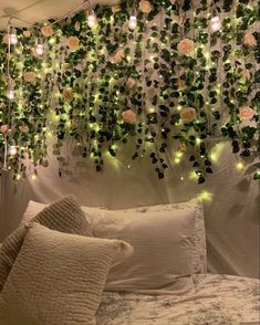 a bed with pillows and lights hanging from the ceiling