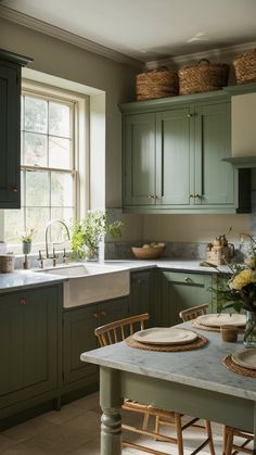 a kitchen filled with lots of green cabinets and counter top space next to a sink