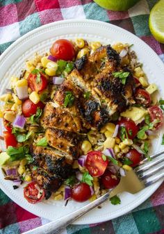 grilled chicken and corn salad on a white plate with a fork next to it