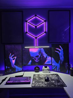 a desk with a keyboard, mouse and monitor in front of purple lights on the wall