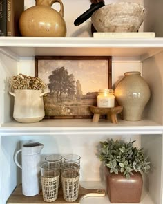 shelves with vases, candles and other items on them in a living room area