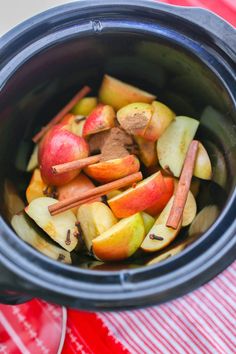 apples and cinnamon sticks are in the crock pot