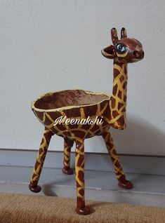 a giraffe statue sitting on top of a brown rug next to a wall