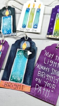 some tags with candles on them hanging from strings