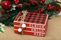 a red and black box sitting on top of a table next to christmas wreaths