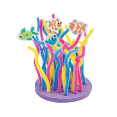 an assortment of colorful plastic toys on a purple base with fish and corals in the background