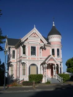 an old pink house with a steeple on the top and stairs leading up to it