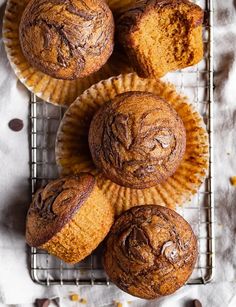 three muffins sitting on top of a cooling rack next to some chocolate chips