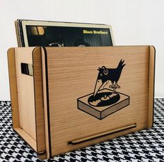 a wooden box with an image of a bird on it's side and a record player in the back