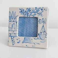 a blue and white photo frame sitting on top of a table