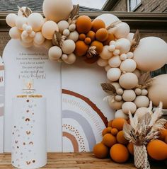 an arch made out of balloons and other decorations on a wooden floor next to a building